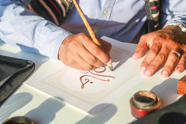 Comment les pratiques de la calligraphie cursive arabe peuvent-elles être adaptées pour créer des logos contemporains ?